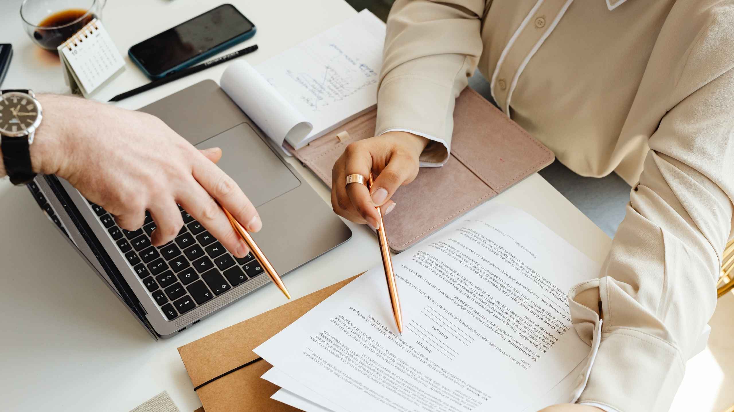 dos personas haciendo la revisión de un documento sobre un escritorio solo se ven manos Qué revisar antes de presentar tu declaración contadora laura barbosa