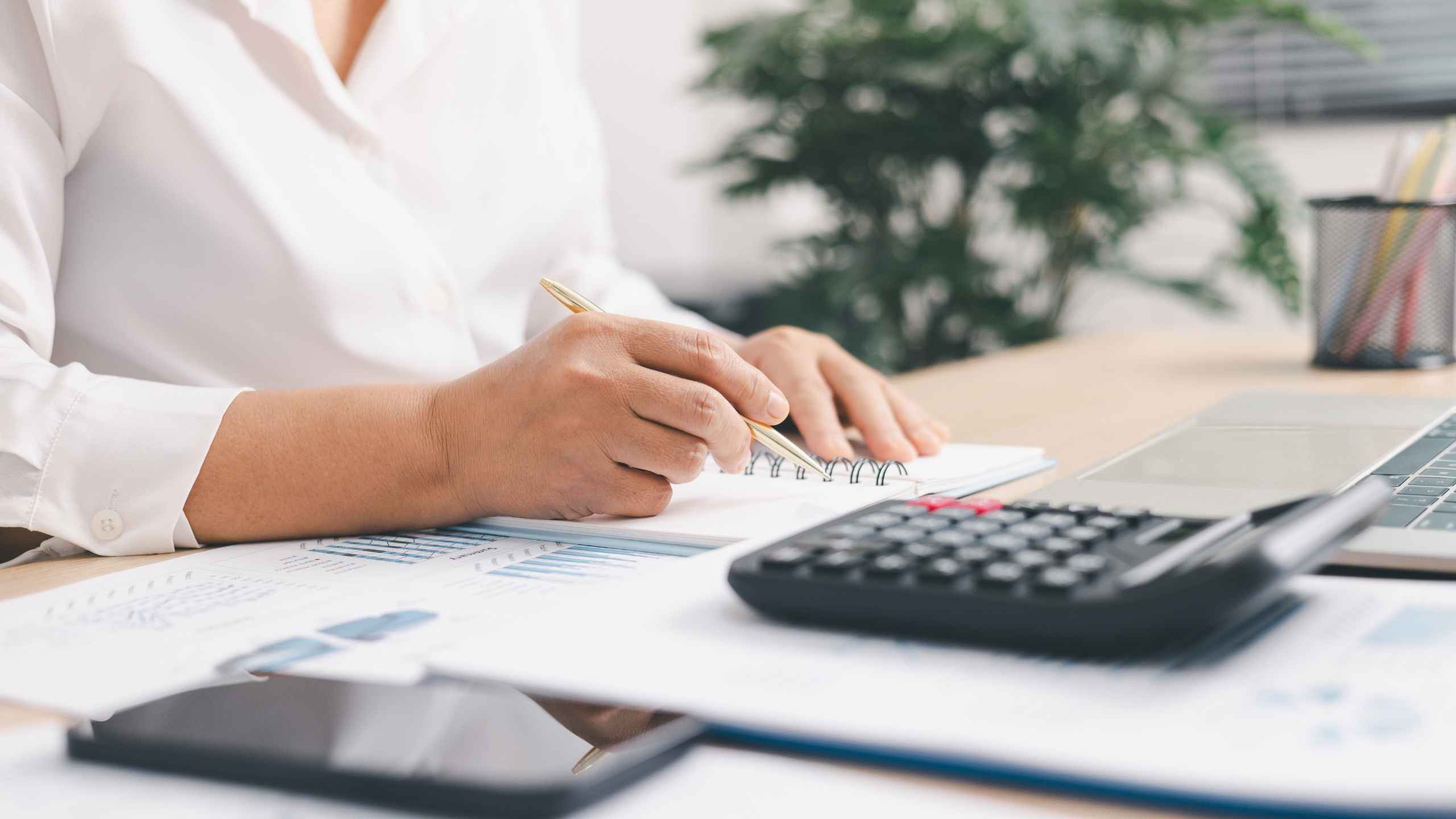 persona haciendo cuentas con una calculadora y un cuaderno en la mano, con un esfero Declaración de renta 2026: fechas de octubre y qué revisar 2026